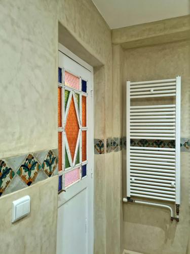 a bathroom with a white door and a window at Maison d'hôte Bousaid in Chefchaouene
