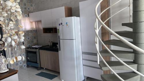 eine Küche mit einem weißen Kühlschrank und einer Wendeltreppe in der Unterkunft Mandakaru Residence Flat da Isa 01 in Porto De Galinhas
