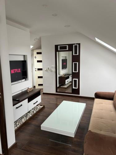 a living room with a couch and a tv at Sarajevo Sky Suite in Sarajevo