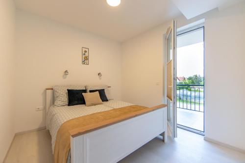 een slaapkamer met een bed en een balkon bij Opal Apartments in Balatonkenese