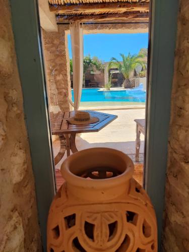 a large vase in a doorway with a view of a pool at Dar Volubilis spacieuse villa avec piscine, 5 chambres vue sur forêt in Essaouira