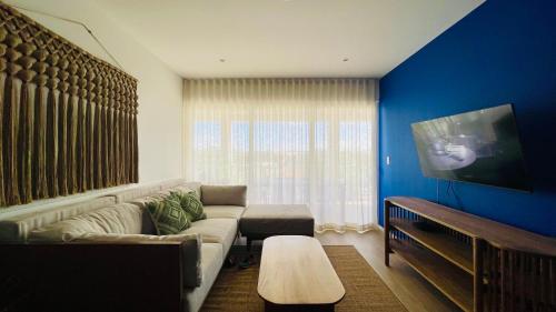 a living room with a couch and a tv at Cozy Terrace @ Blue House in Puerto Aventuras