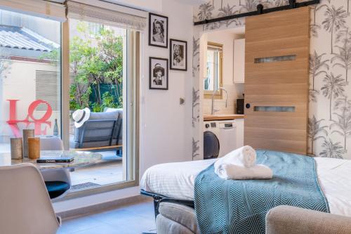 une chambre avec un lit et une grande fenêtre dans l'établissement RARE ! Studio with terrace 5min walk to the Palais, à Cannes