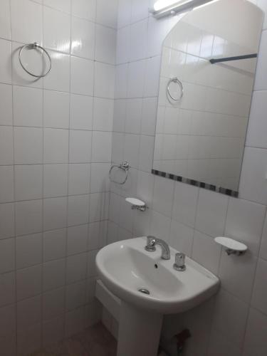 a white bathroom with a sink and a mirror at Precioso departamento en Maipú in Maipú