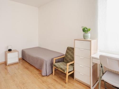 a bedroom with a bed and a chair and a desk at Private room in Art Centre 