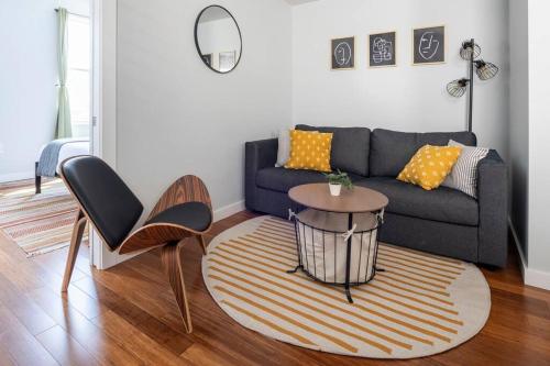 a living room with a couch and a table at OTR, QUEEN Bed, 50in TV, Workspace, Near Lightrail in Cincinnati