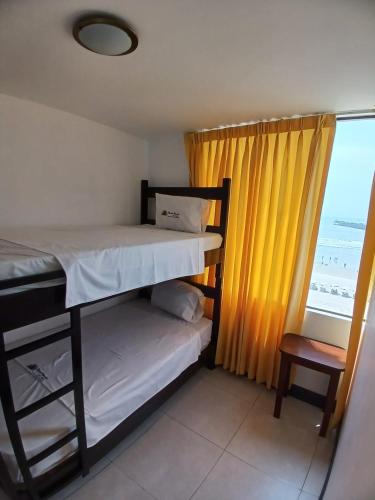 1 dormitorio con litera y ventana en Hotel Garuda Pimentel, en Pimentel