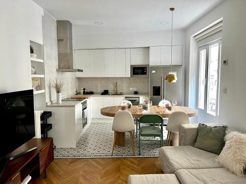 een keuken en een woonkamer met een tafel en een bank bij Apartamento Marqués de Villores centro in Albacete