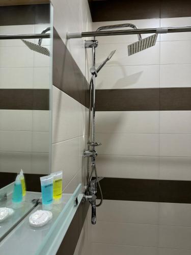 a bathroom with a shower and two sinks and a mirror at guest house TMT in Sighnaghi