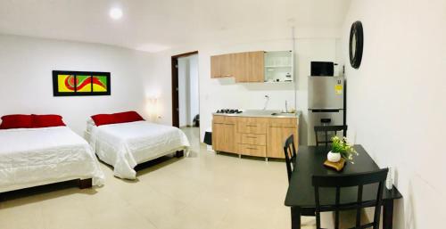 聖安德烈斯的住宿－Apartahotel Bahia Tropical II，一间带一张床和一张书桌的卧室和一间厨房