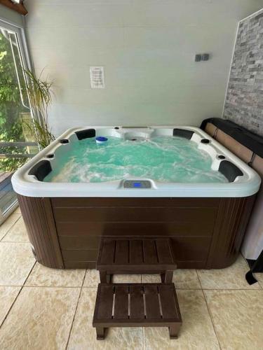 a jacuzzi tub with a bench in a room at Magnificent 18th Century, 5 Star Luxury Spa in Melleray-la-Vallée