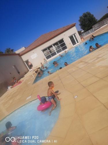 un jeune garçon jouant dans une piscine dans l'établissement Mini villa villa Gallargues le Montueux jardinet / piscine partagée, à Gallargues-le-Montueux