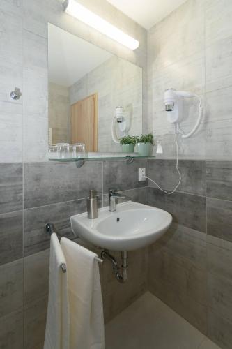 a bathroom with a sink and a mirror and towels at Solid Gold Garni Hotel in Malacky