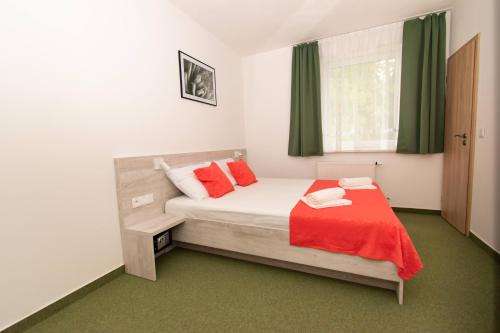 um quarto com uma cama com um cobertor vermelho em Solid Gold - OPENING AUGUST 2024 em Malacky