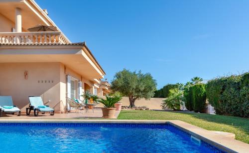 a villa with a swimming pool next to a house at Villa Palmera in Palma de Mallorca