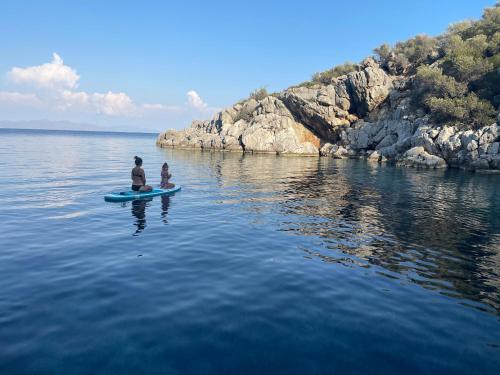 a man and a child on a paddle board in the water at OluGide Tekne Turu in Datca