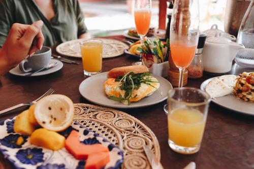 a table with plates of food and glasses of orange juice at Sazagua Hotel Boutique in Pereira