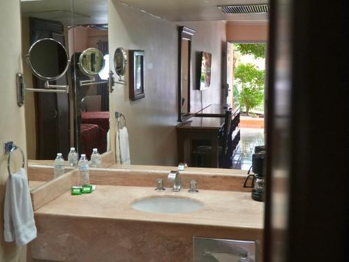 a bathroom with a sink and a mirror and a piano at Hotel San Angel in Hermosillo