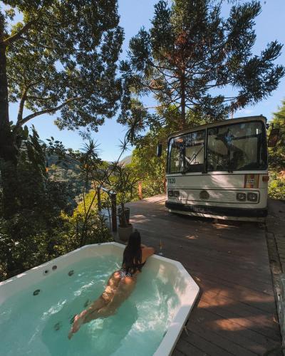 多明戈斯馬丁斯的住宿－Ônibus Retrô - Domingos Martins/ES，躺在公共汽车旁的浴缸里的女人