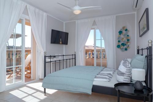 a bedroom with a bed with a ceiling fan at Villa Palmera in Palma de Mallorca