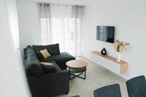 ein Wohnzimmer mit einem Sofa und einem Tisch in der Unterkunft Apartment Castellano in Kaštela
