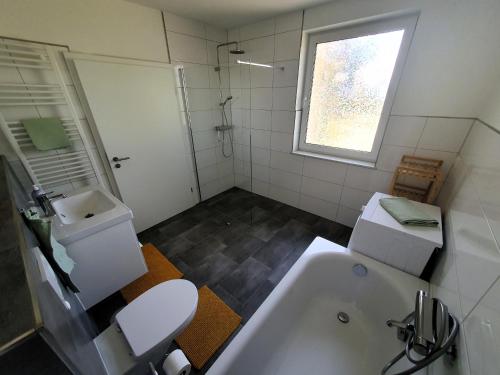 uma casa de banho com uma banheira, um WC e um lavatório. em Ferienhaus Winkler - FeWo Nordland - KEINE MONTEURE em Schwerin