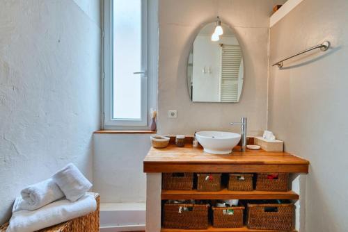 une salle de bain avec un lavabo et un miroir dans l'établissement typique maison de village d'allauch, à Allauch