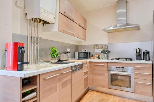 une grande cuisine avec des placards en bois et des appareils en acier inoxydable dans l'établissement typique maison de village d'allauch, à Allauch