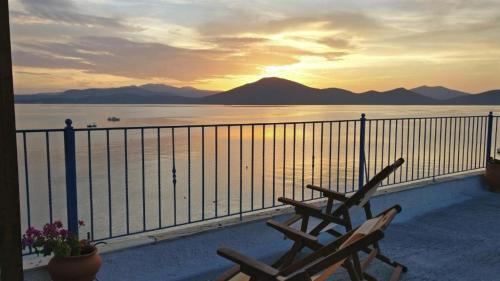 a couple of benches sitting on a balcony watching the sunset at Papas Studios On the Seafront in Oreoí