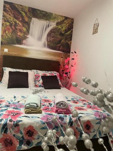 a bedroom with a bed with a painting of a waterfall at Villa Zigana in Mostar