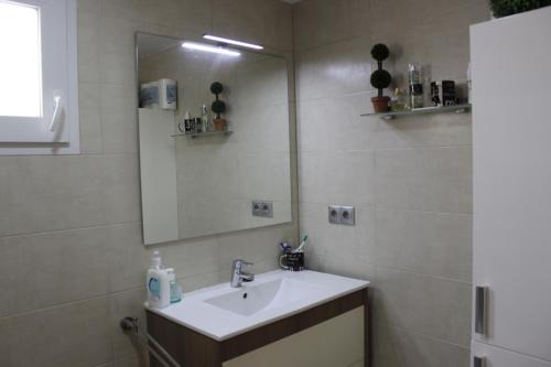 bagno con lavandino e specchio di El Descans Solo Familias Serviplaya a Casas Las Basas