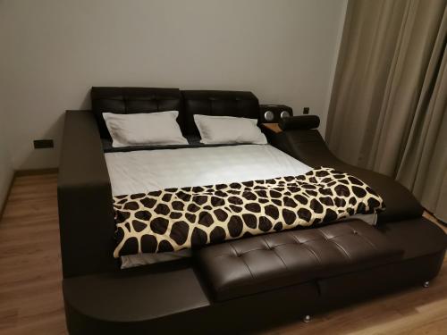 a black bed with a black and white comforter at Villa d’Ebene in Ebene