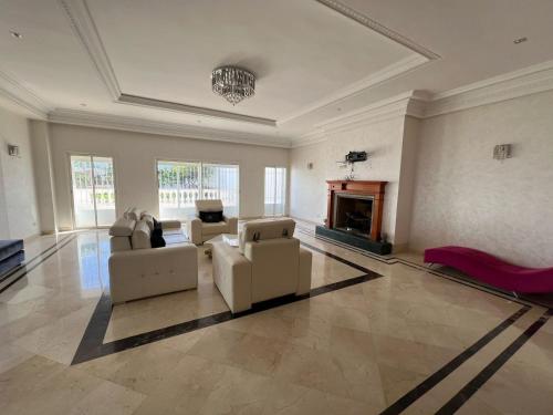 un grand salon avec des canapés et une cheminée dans l'établissement Villa 3alame, à Temara