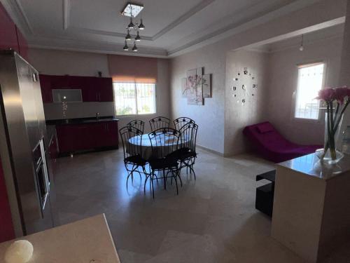 - une cuisine et une salle à manger avec une table et des chaises dans l'établissement Villa 3alame, à Temara