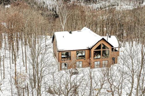 une maison recouverte de neige dans l'établissement The Glam Shack - Golf, Ski, Spa, à Saint-Faustin–Lac-Carré