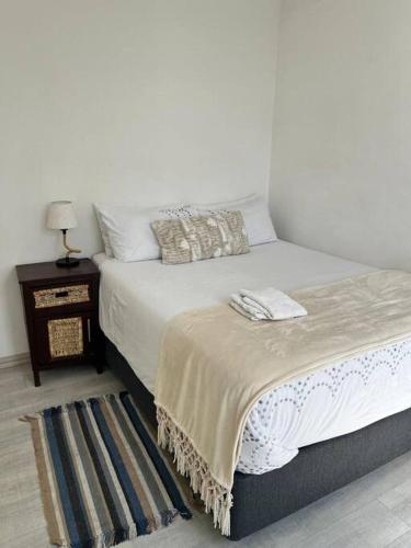 una camera con letto e tavolo con lampada di DMN City Junction Apartment a Windhoek