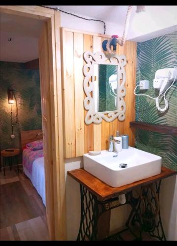 a bathroom with a sink and a mirror and a bed at IL Vicoletto in Serra San Bruno