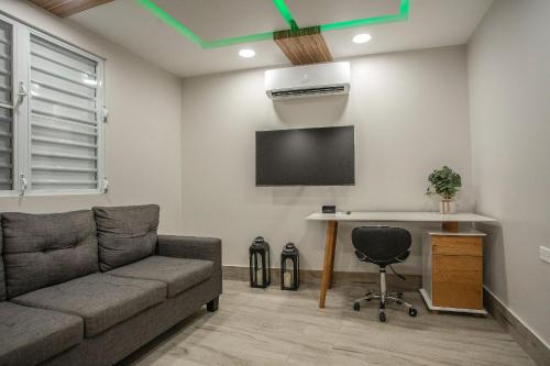 a living room with a couch and a table and a tv at EcoMar Rentals in Cabo Rojo