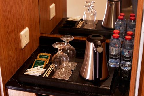 a kitchen counter with bottles of water and glasses at فندق روزن المسك مكة توصيل للحرم in Al ‘Azīzīyah