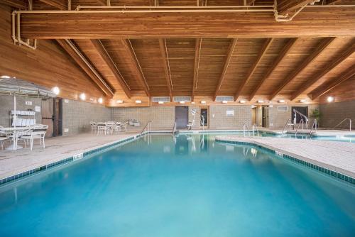 a large swimming pool with a wooden ceiling at AmericInn by Wyndham Green Bay East in Green Bay