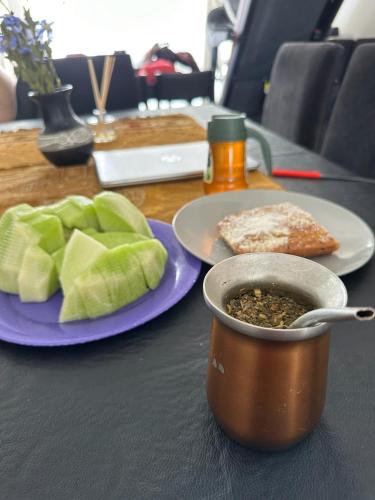 einen Tisch mit einer Schüssel Essen und einem Teller Salat in der Unterkunft Apart vista al Mar in Comodoro Rivadavia