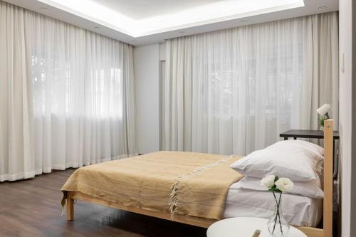 - une chambre avec un grand lit et des rideaux blancs dans l'établissement Ultra-modern 4BR in Maadi Degla, au Caire