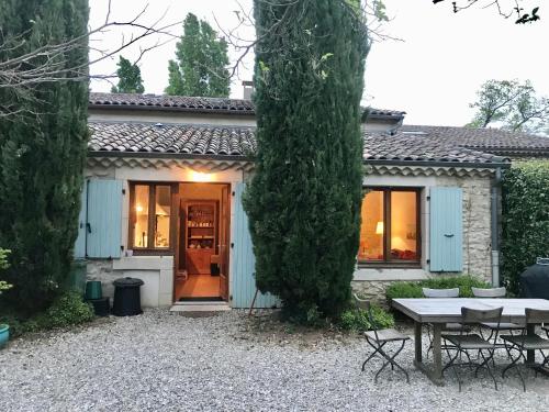 a house with a table and chairs in front of it at Charme de la pierre, pour cette maison de vacances in Grane
