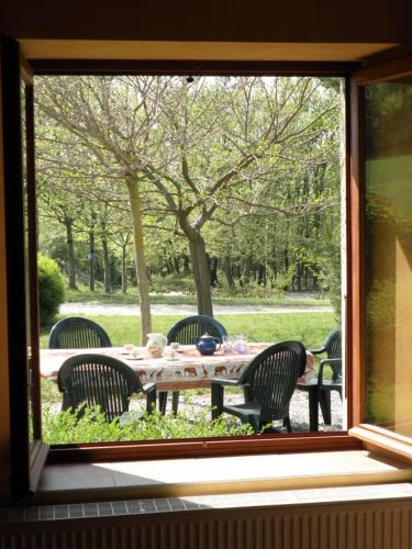 - une vue sur une table et des chaises depuis la fenêtre dans l'établissement Charme de la pierre, pour cette maison de vacances, à Grane