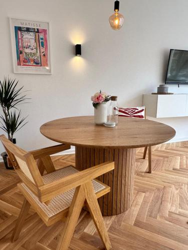 una mesa de madera y sillas en la sala de estar. en Exklusive Ferienwohnung im Stadtzentrum - 24h Check-in, en Kiel