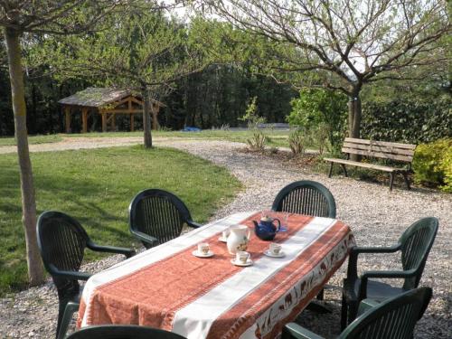 a table with four chairs and a table with at Charme de la pierre, pour cette maison de vacances in Grane