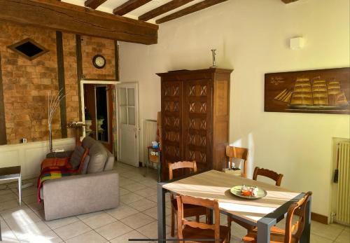 un salon avec une table et un canapé dans l'établissement Maison de l horloge, à Avallon