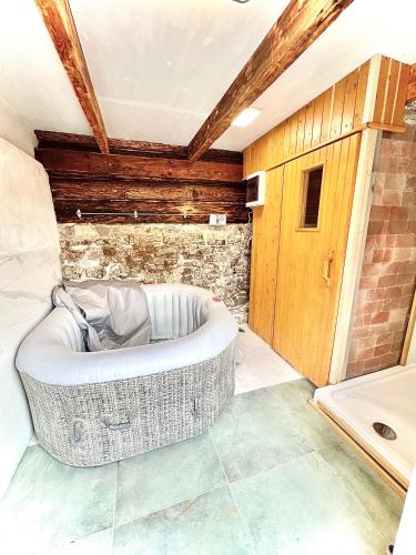 a bath tub in a room with a brick wall at Santova roubenka in Štramberk