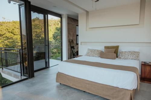 ein Schlafzimmer mit einem großen Bett und einem Balkon in der Unterkunft Vida Palace in Jacó