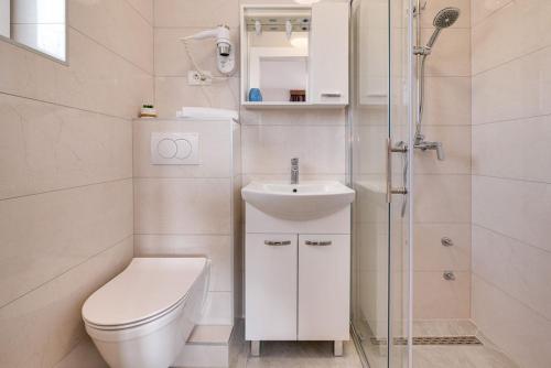 La salle de bains est pourvue de toilettes, d'un lavabo et d'une douche. dans l'établissement Bed & Breakfast Došen, à Baška